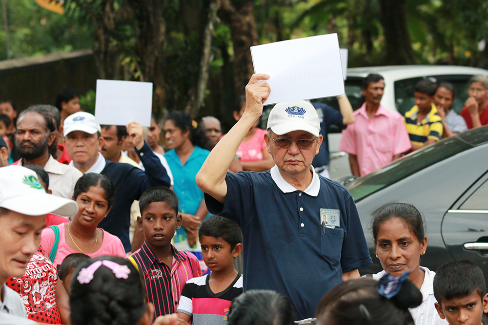 Mr. Sim Hee Chew frequently travelled with Tzu Chi volunteers to places such as Sri Lanka, Cambodia, and the Philippines to conduct free clinics and rice distribution programmes. He was not afraid of the hard work and was able to connect well with the locals. (Photo by Chua Teong Seng)